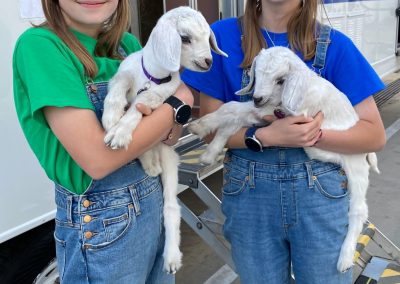 Twin goats with twin girls! (Our neighbors were twin girls who brought twin kids with them. Their adult goats performed on our episode.)